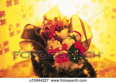 Stock Photo - Christmas figurines on wrapping paper, high angle view, toned image. Fotosearch