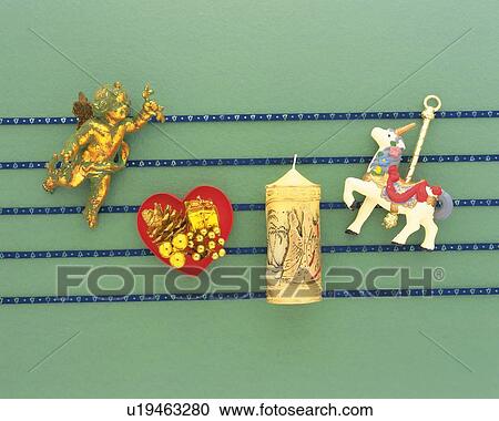 Stock Image - Christmas ornaments on blue lines, green background, high angle view. Fotosearch