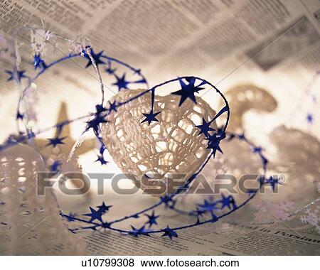 Stock Photo - Christmas ornaments on newspaper, close up. Fotosearch