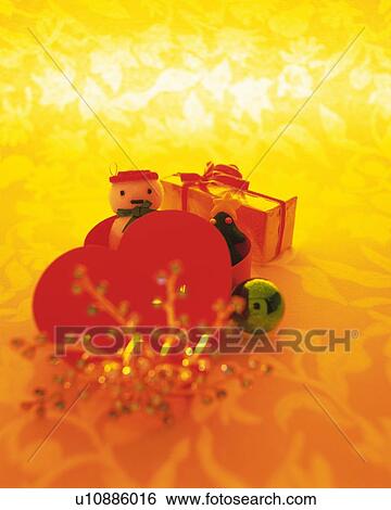 Stock Photograph - Christmas ornaments, snowman and Christmas tree in heart shaped box, front view. Fotosearch