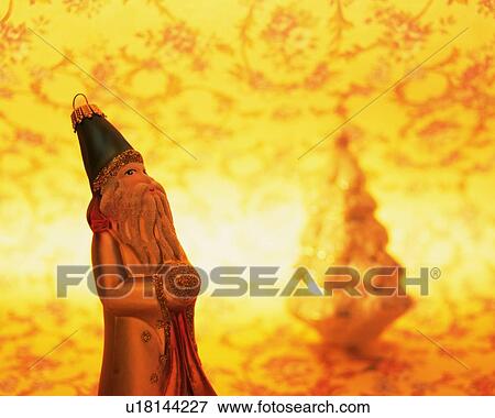Stock Photo - Figurines of Santa Claus and Christmas tree, side view. Fotosearch