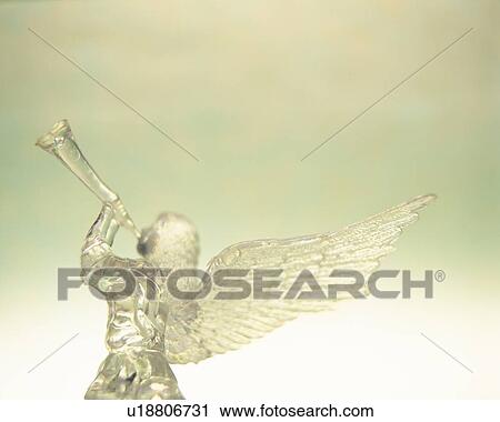Stock Image - Glass angel playing trumpet, rear view. Fotosearch