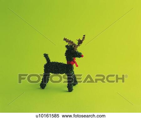 Stock Photography - Reindeer ornament, side view, green background. Fotosearch