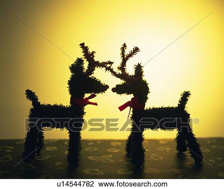 Stock Image - Two reindeer ornaments standing face to face, side view. Fotosearch