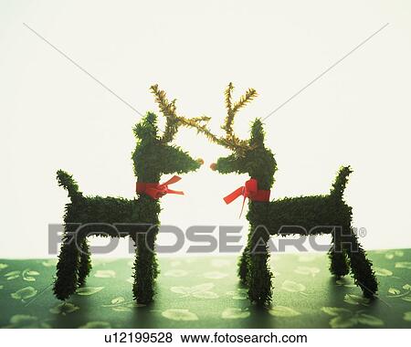 Two reindeer ornaments standing face to face, side view View Large Photo Image Stock Photo - Two reindeer ornaments standing face to face, side view. Fotosearch