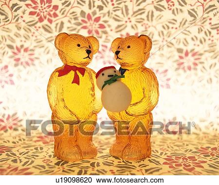 Stock Image - Two teddy bears standing and holding snowman, front view, composition. Fotosearch