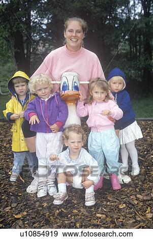 Stock Photo - A childcare worker with her group of children. Fotosearch