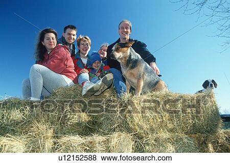 Stock Photo - A family sitting on hay bales. Fotosearch