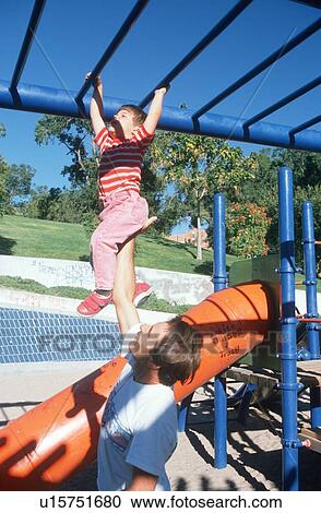 Stock Image - A father and daughter playing on the jungle gym. Fotosearch