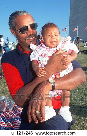 African-American man holding his granddaughter at the Washington National Monument View Large Photo Image Stock Photograph - African-American man holding his granddaughter at the Washington National Monument. Fotosearch