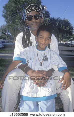 Stock Photo - An African-American father and son embracing . Fotosearch