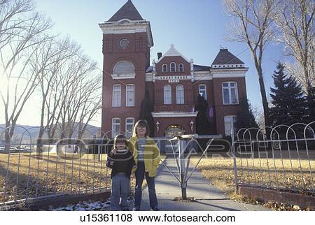 Stock Photo - Brother and sister standing in front of a rural courthouse. Fotosearch