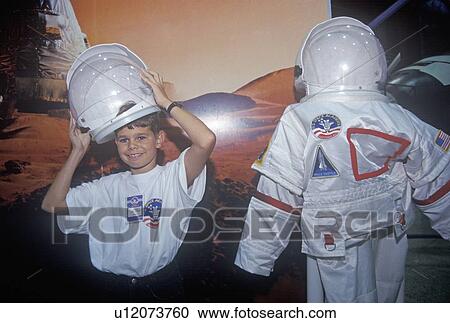 Stock Image - Children try on $1 million spacesuit at Space Camp. Fotosearch