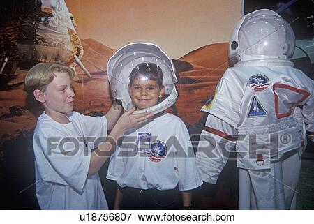 Stock Photo - Children try on $1 million spacesuit at Space Camp. Fotosearch