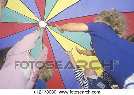 Preschool children playing a parachute game View Large Photo Image Stock Image - Preschool children playing a parachute game. Fotosearch