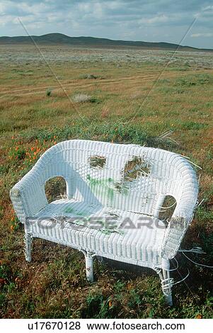 Stock Photo - A white wicker chair in a field. Fotosearch