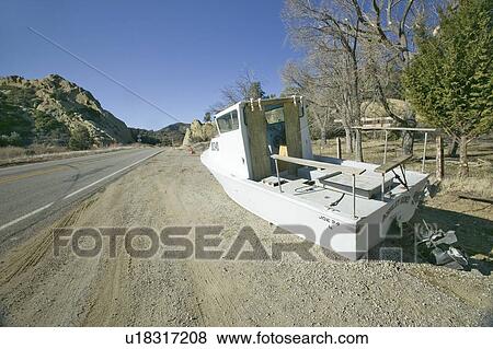 Deserted boat left on side of road View Large Photo Image Stock Photo - Deserted boat left on side of road . Fotosearch