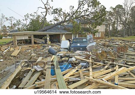 Picture - Fallen tree and debris in front of house heavily hit by Hurricane Ivan . Fotosearch