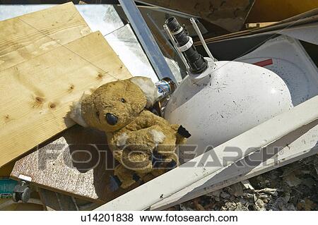 Stock Photo - Teddy Bear on couch sits atop rubble after Hurricane Ivan strikes . Fotosearch