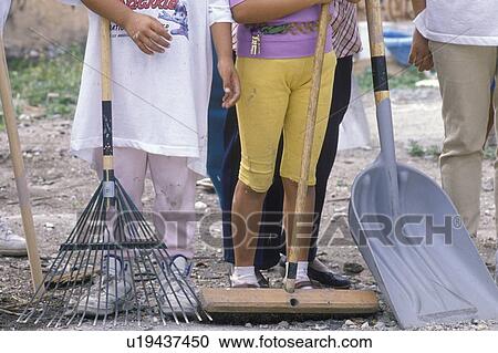 Stock Image - A close-up of women holding cleanup tools. Fotosearch