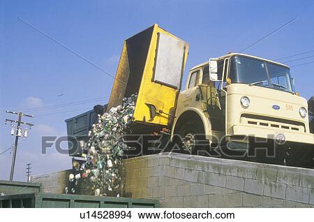 A recycling truck emptying the contents of a yellow bin View Large Photo Image Picture - A recycling truck emptying the contents of a yellow bin . Fotosearch