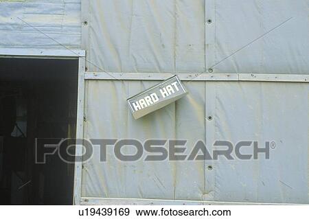Stock Photo - A sign requiring hard hats to be worn on a construction site. Fotosearch