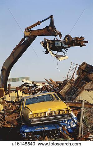 Stock Image - Cars being demolished at wrecking yard. Fotosearch