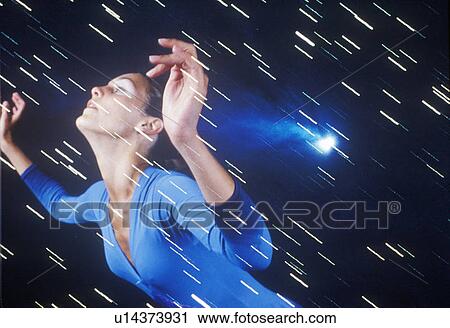 Stock Image - A dancer posing against a starry background. Fotosearch