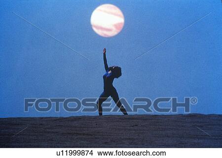 Picture - A dancer posing outdoors in front of the sun. Fotosearch