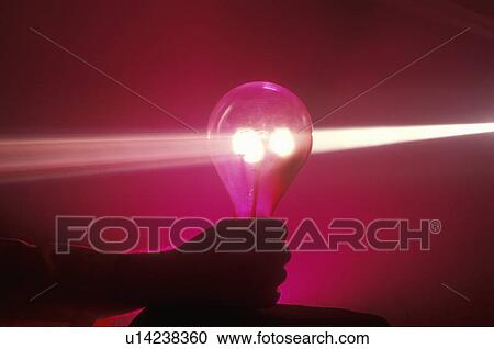 Stock Image - A lightbulb illuminated with a beam of light colors from a laser. Fotosearch