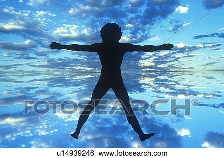 Stock Photograph - Clouds and blue sky behind silhouette of New Age Man. Fotosearch