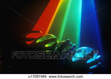 Picture - Several multi-colored spheres appearing as planets with laser lights shining through. Fotosearch