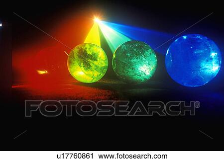 Stock Image - Several multi-colored spheres appearing as planets with laser lights shining through. Fotosearch
