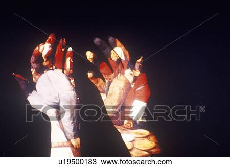 Stock Image - Special effects composite of posterized silhouette of two hands and black sky. Fotosearch