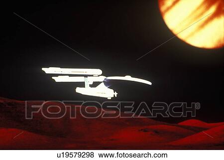 Stock Photo - Star Trek's USS Enterprise soars over and alien landscape. Fotosearch