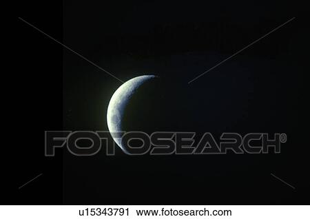 Stock Image - A crescent moon against a black starless sky. Fotosearch