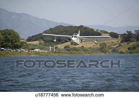 Stock Photograph - Amphibious seaplane taking off from Lake. Fotosearch