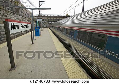 Stock Image - Train departs from train station, New Rochelle New York. Fotosearch