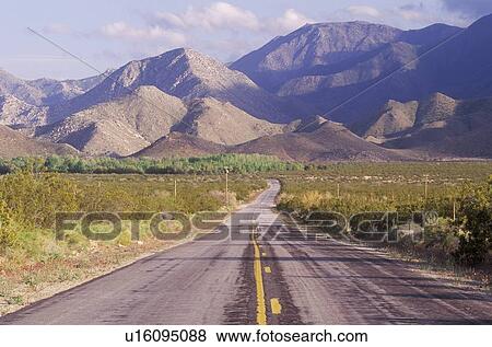 Empty highway moving toward mountains View Large Photo Image Stock Photo - Empty highway moving toward mountains. Fotosearch