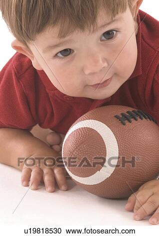 Close-up of a baby boy lying on a football View Large Photo Image Stock Image - Close-up of a baby boy lying on a football. Fotosearch