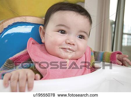Stock Photo - Close-up of a baby girl eating. Fotosearch