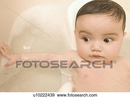 Stock Photo - Close-up of a baby girl in a bathtub. Fotosearch