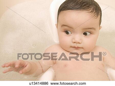Stock Photograph - Close-up of a baby girl in a bathtub. Fotosearch