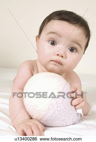 Close-up of a baby girl lying on her stomach View Large Photo Image Stock Photograph - Close-up of a baby girl lying on her stomach. Fotosearch