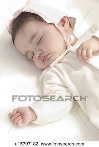 Stock Image - High angle view of a baby girl sleeping. Fotosearch