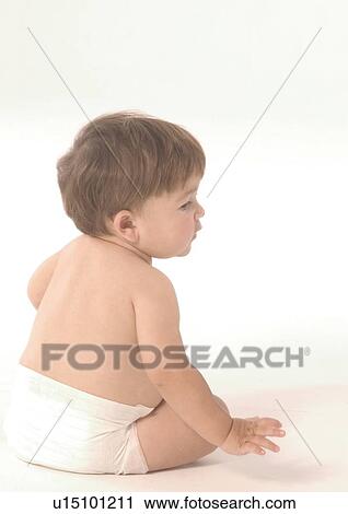 Stock Image - Rear view of a baby boy sitting up. Fotosearch