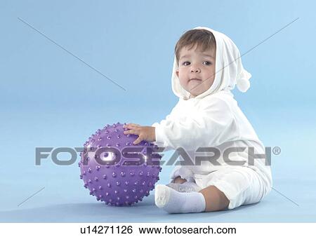 Stock Photograph - Side profile of a baby boy holding a ball. Fotosearch