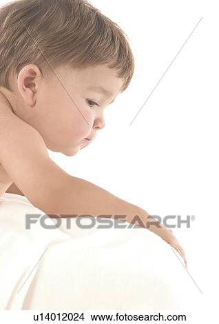 Picture - Side profile of a baby boy looking over a pillow. Fotosearch