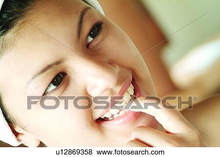 Stock Photo - Fun, Indoor, Focus On Foreground, Looking Away, Finger On Lips, Close-Up, One Person. Fotosearch