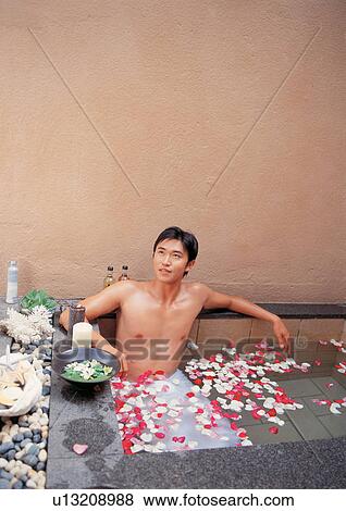 Stock Photo - floating, happy, petals, bowl, black hair, young adult. Fotosearch